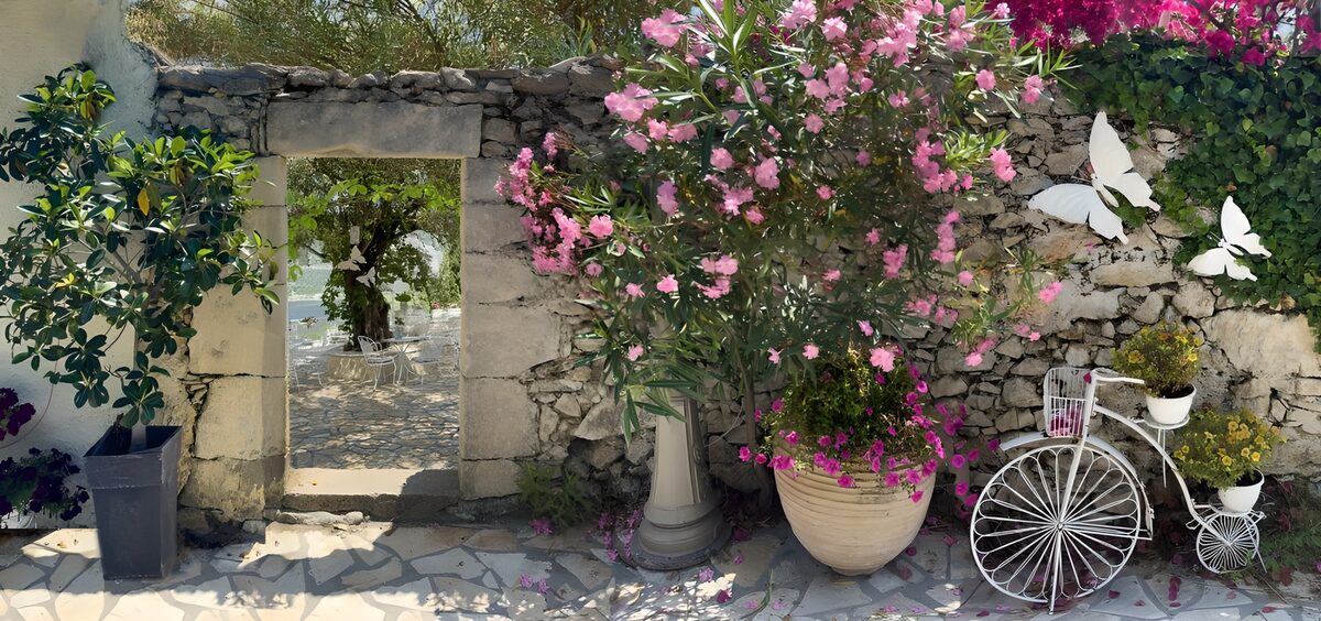 See-through old wall with passage to patio and old bicycle with flowers