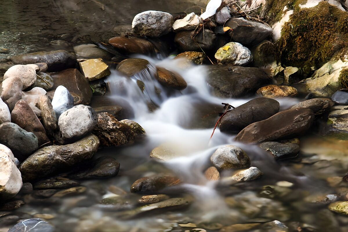 Serene Stream Flowing Over River Rocks