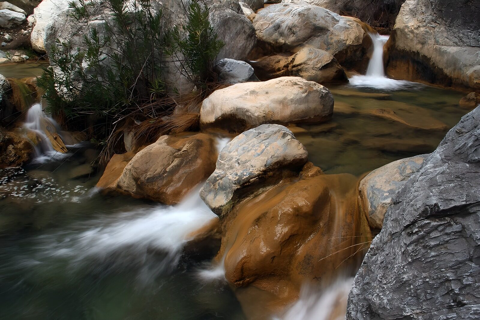 OCCOM3447194: Serene Stream Flowing Through Rocky Landscape